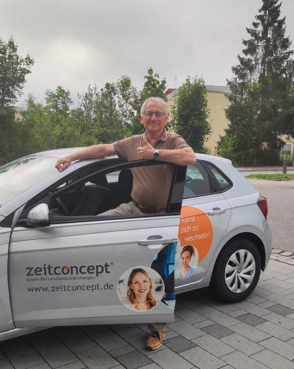 Fahrer Ludwig mit erhobenem Daumen an der geöffneten Tür eines mit zeitconcept-Werbung beklebten Fahrzeugs